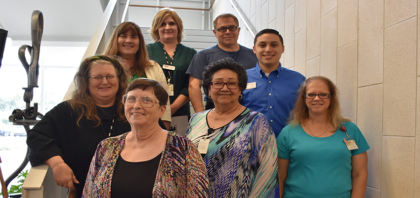 Staff members pose for photo on the stairs in UHV North building.