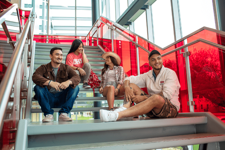 UHV students in the South STEM building sitting on the stairs and posed