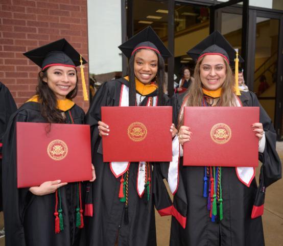 Three students hold diplomas