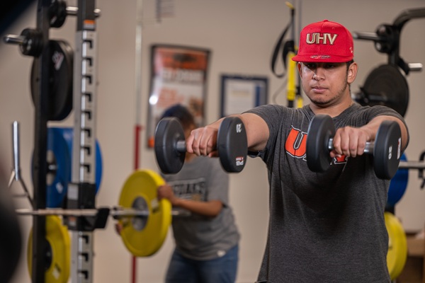 Male student working out with free weights