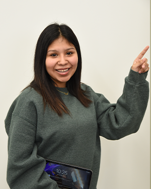 A female student holding a tablet and pointing