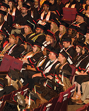 Graduates in caps and gowns seated at commencement ceremony