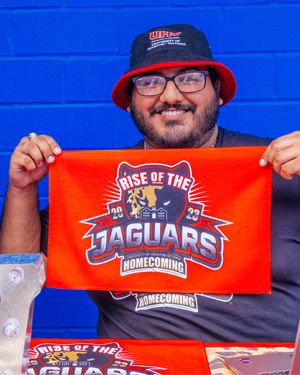 UHV student holding up UHV Homecoming 2023 towel
