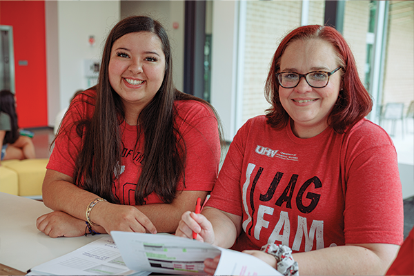 Two female students collaborating on a paper.