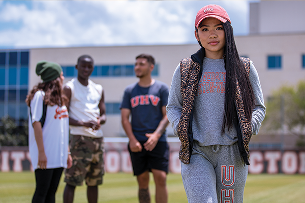 A female student, at the UHV soccer field, wearing UHV apparel.