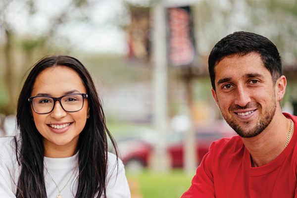 A male and female student smile for the camera.