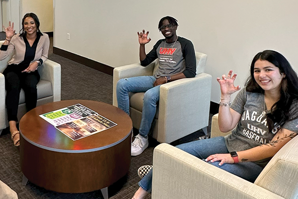 Three students doing the UHV Hand Sign