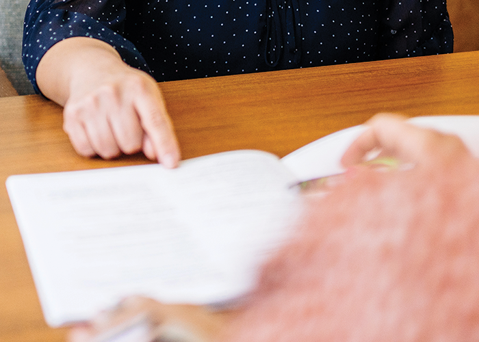 person pointing to content in a book
