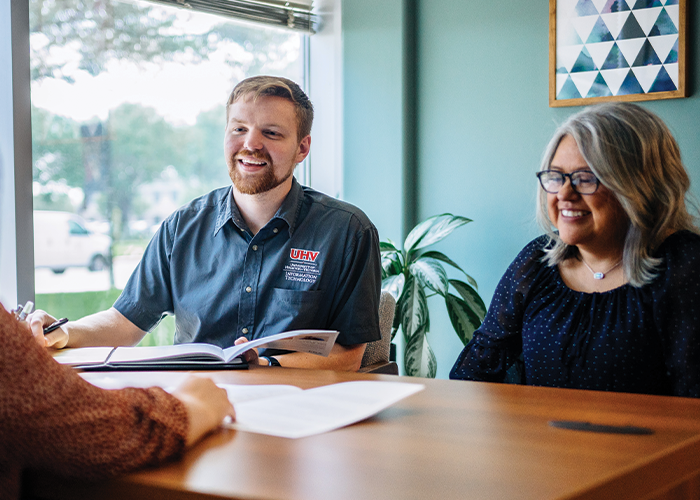 Staff sitting at a table holding documents.