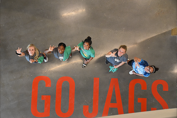 Students doing UHV Hand Sign with message, Go Jags