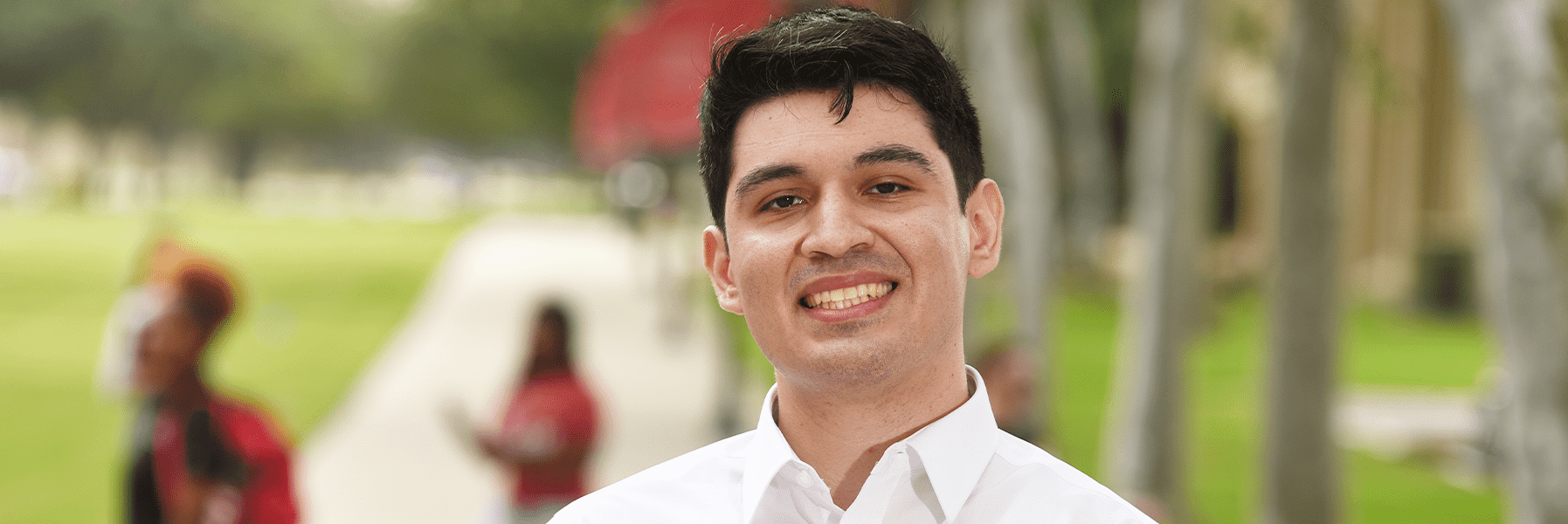 Student outside, smiling for camera.