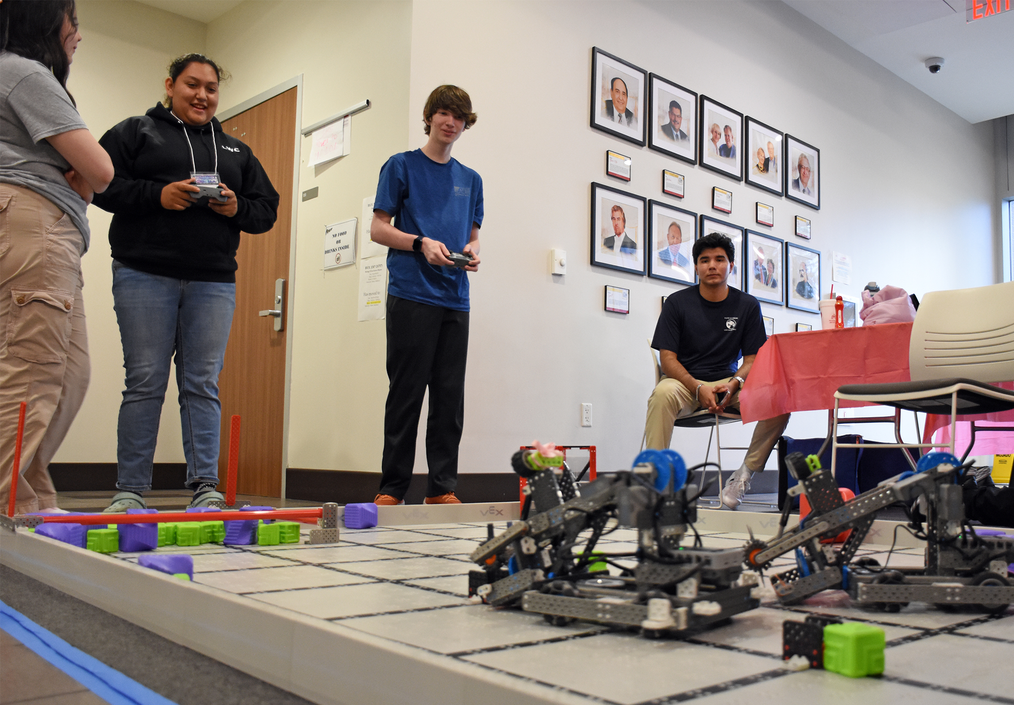 Students use remotes to steer a robot.