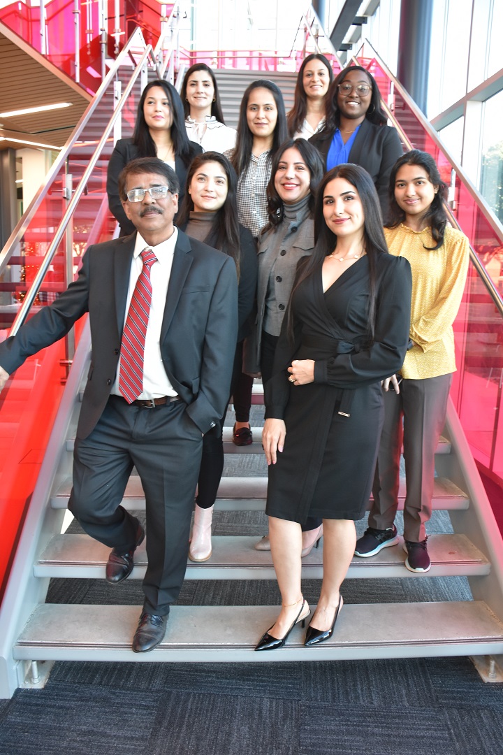 A group of nine 2024 Biology graduate students and a professor, posing on a staircase.