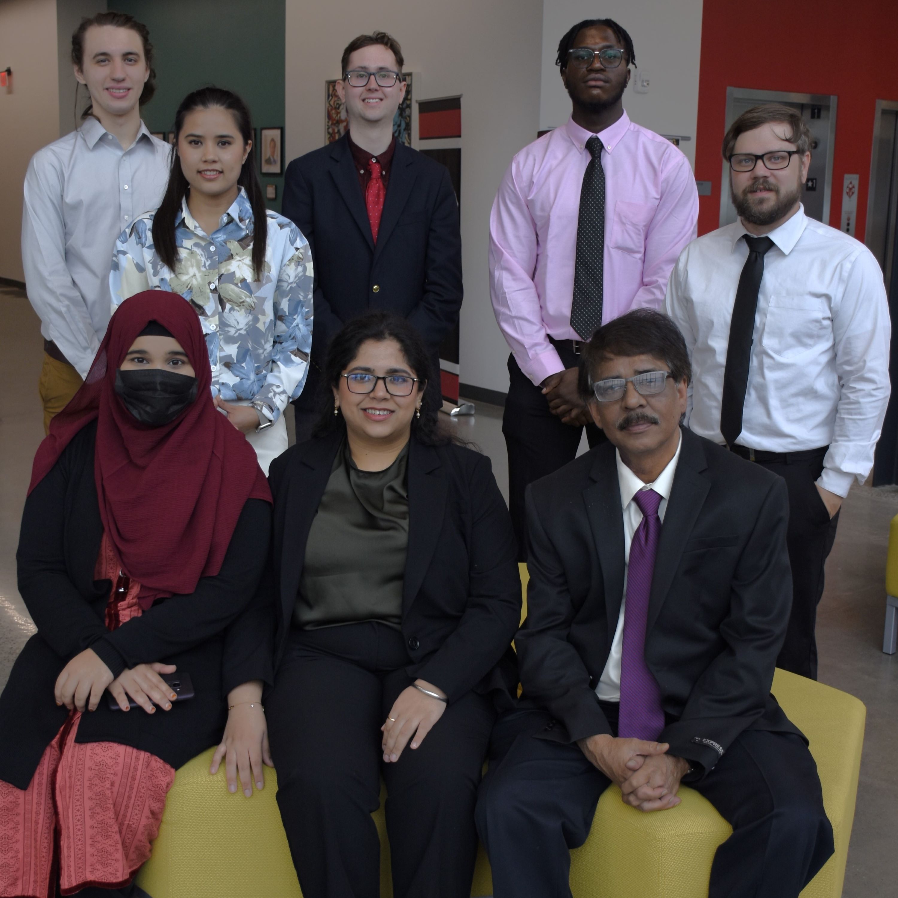 Seven students pose with a faculty member