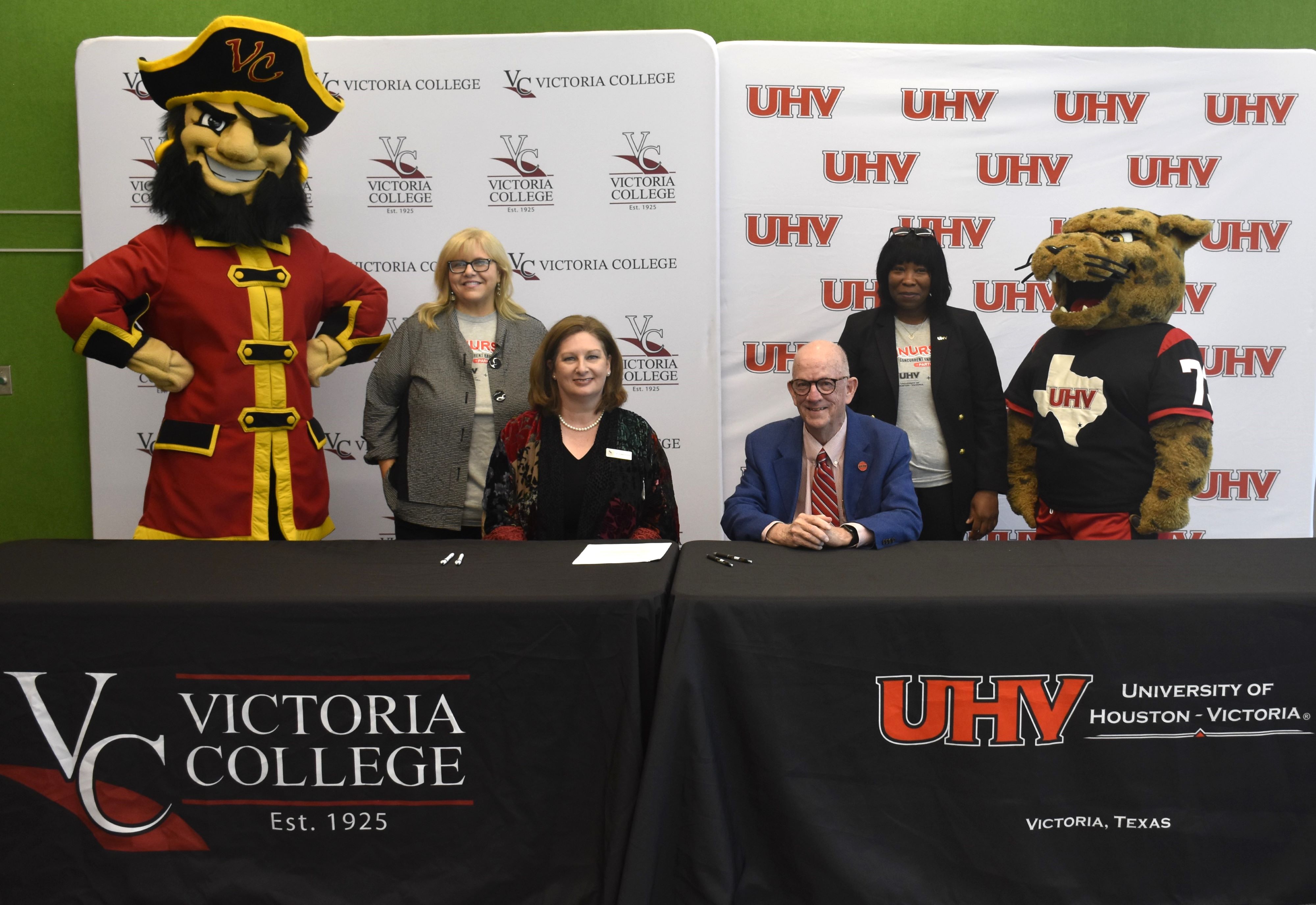 UHV and VC administrators pose with Captain Vic and jaX at a ceremony.