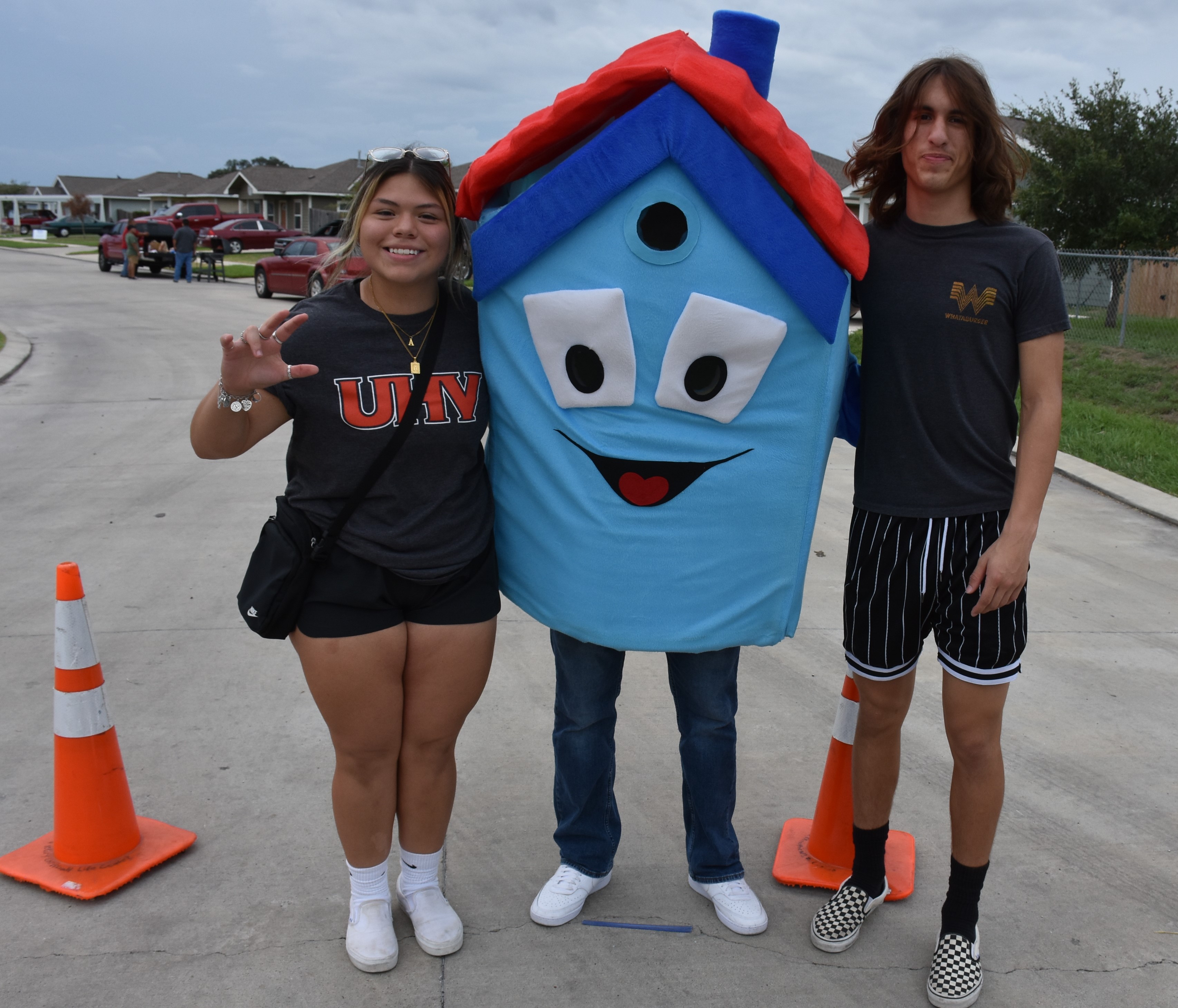 UHV students Alyssa Sauceda, a freshman from Victoria, left; Giovanni Gonzalez, a freshman from Brownsville, center; and Israel Sauceda, a dual credit homeschool student from Victoria; pose for a photo Monday while directing traffic during the Golden Crescent Habitat for Humanity's Myra Lane Block Party event.