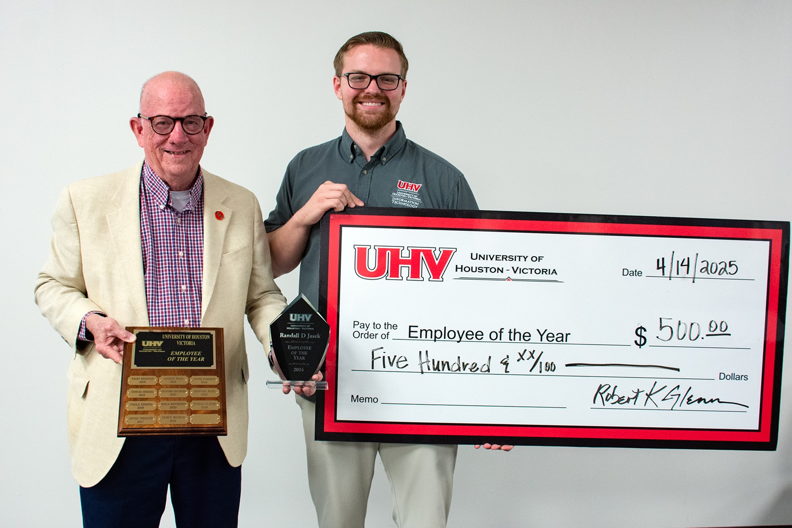 Randall Jasek receives his 2024 Employee of the Year award from UHV President Bob Glenn.