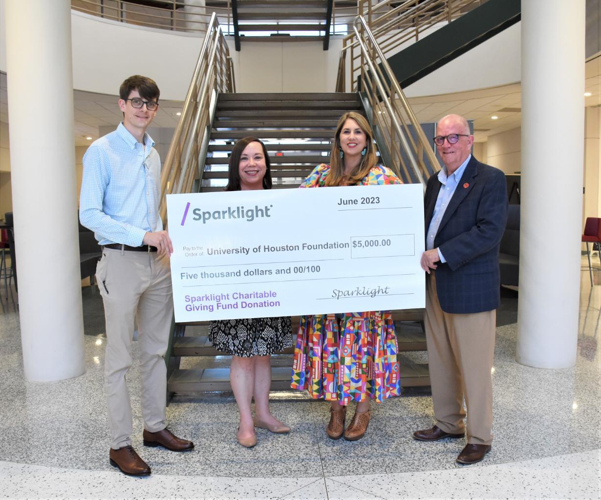 Sparklight and UHV officials post with a large check.