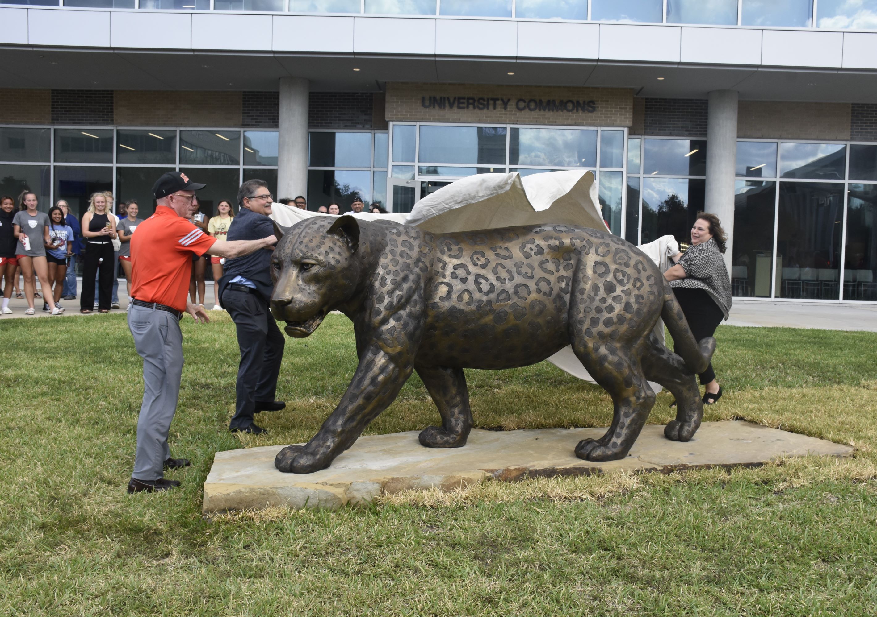 UHV President Bob Glenn and Ben and Diana Galvan unveil the new jaguar statue.