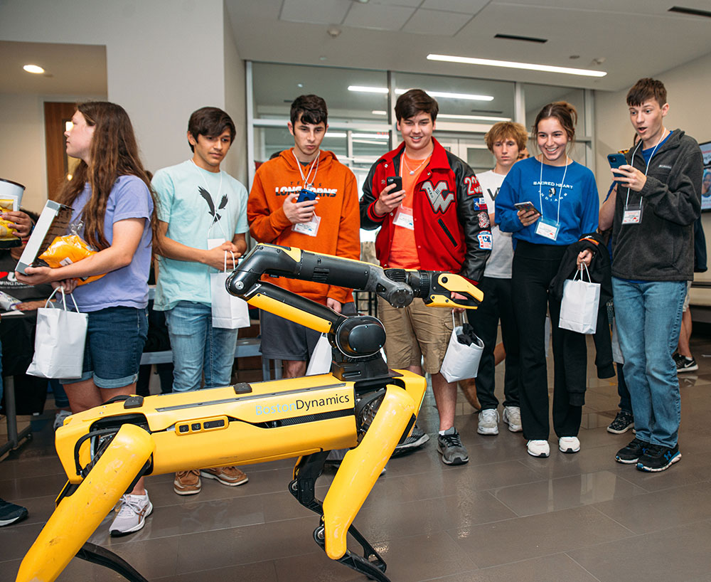 Students observe robot dog in demonstration.