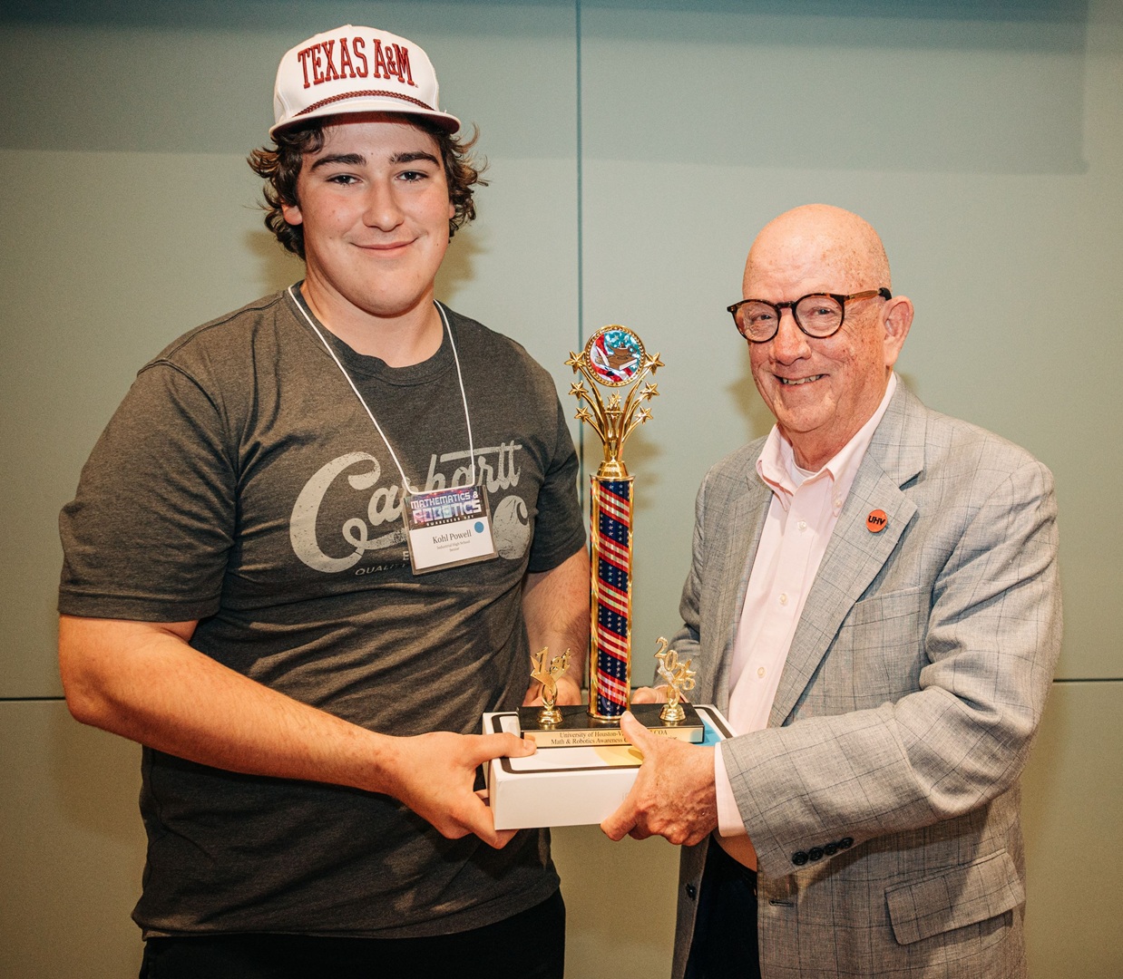 Kohl Powell accepts his first-place trophy and iPad from UHV President Bob Glenn.