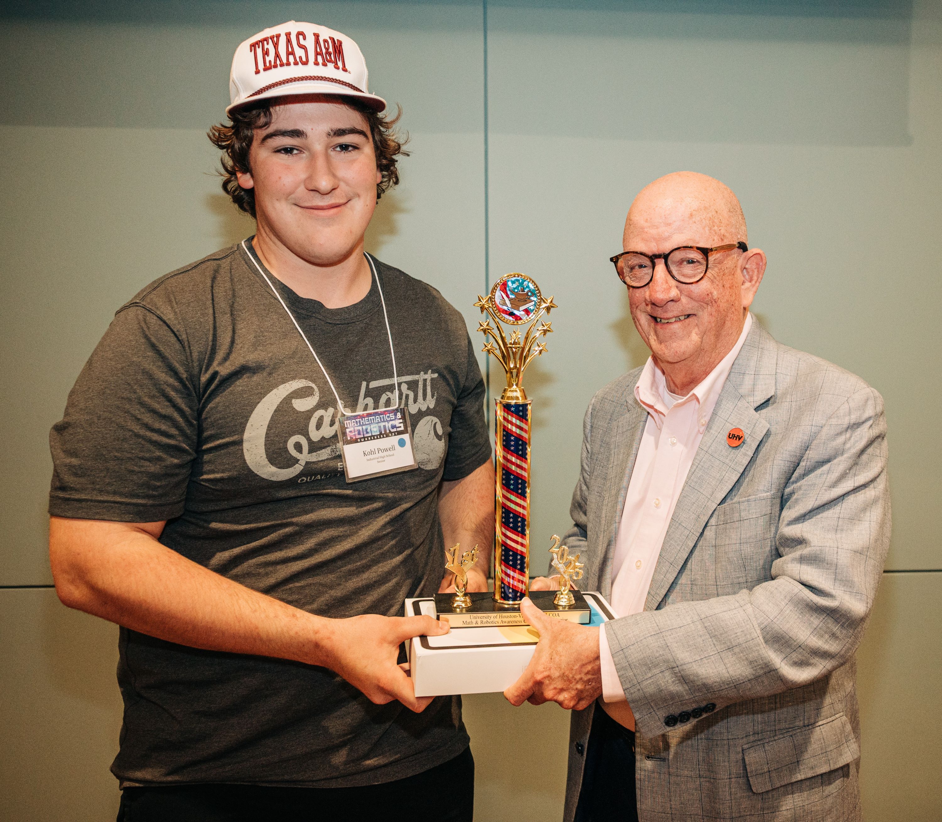 Kohl Powell accepts his first-place trophy and iPad from UHV President Bob Glenn.