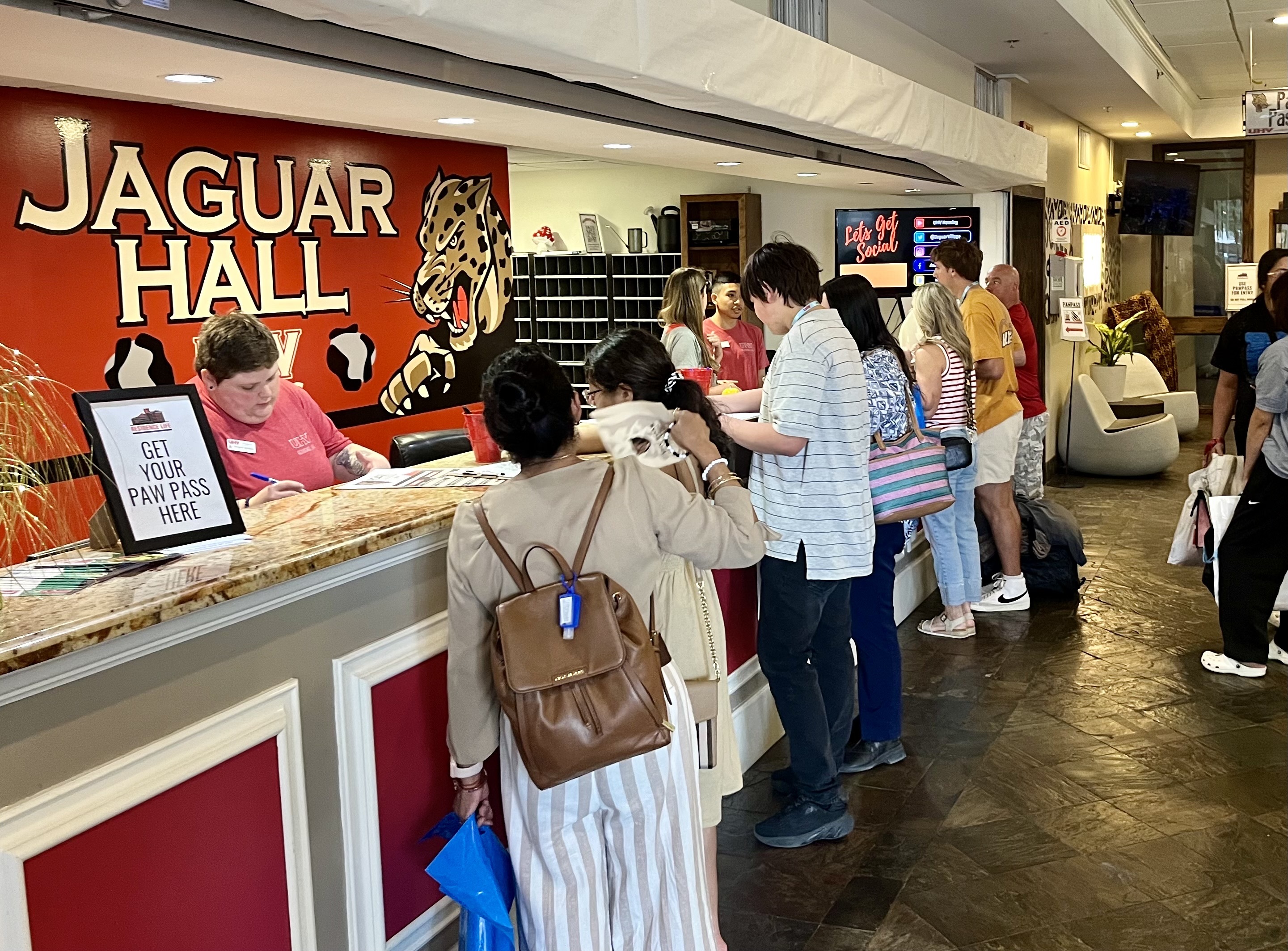 Students lined up at the counter of the Jaguar Hall reception desk
