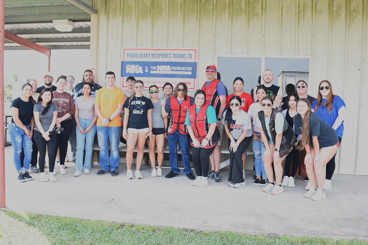 A group of students stand in front of a sign thanking the NRA Foundation for its grant/